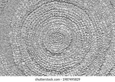 Grunge texture of an ethnic circular hand-knitted rug. Monochrome background boho style mat woven from natural organic fibers with spots, fibers and noise. Overlay template. Vector illustration