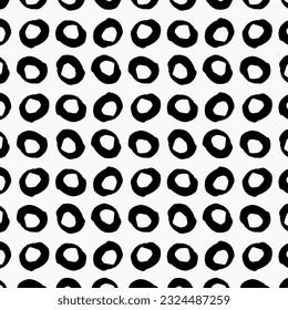 Grunge vector seamless pattern featuring a hand-drawn ink dirty circles texture. The pattern consists of black paint dry brush blotches, creating a background that imitates an animal pattern. The circ