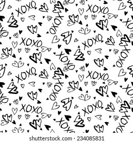 Grunge vector seamless pattern with hand painted hearts and words xoxo. Bright ditsy print for valentines day wrapping paper decor or wedding invitation card background in black and white colors