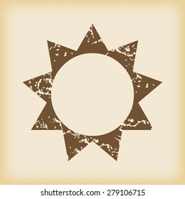 Grungy brown icon with image of sun, on beige background
