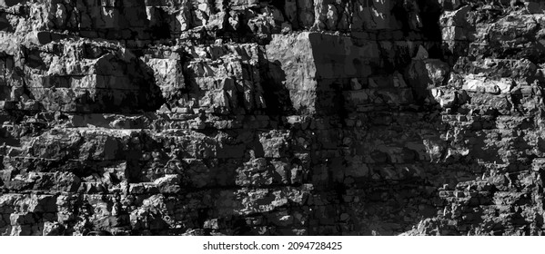 Grungy cragged bumpy pitted cavity stone facade, split layer gap.Ruined cracked shattered worn rough hiking canyon.Old ragged grunge steep marble cliff. Grand vintage crannied damaged impressive gorge