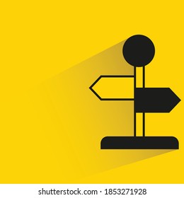 guidepost with shadow on yellow background