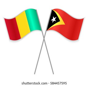 Guinean and Timorese crossed flags. Guinea combined with East Timor isolated on white. Language learning, international business or travel concept.