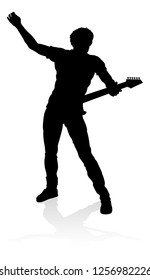 A guitarist musician in detailed silhouette playing his guitar musical instrument.