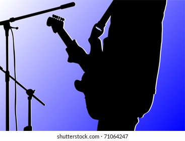 Guitarist stands on stage in front of a microphone on a blue background