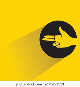 Botón del círculo de la muestra de la mano de la pistola con la sombra sobre fondo amarillo