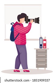 The guy with backpack standing with the camera in his hands. The photographer takes pictures in the office. Photographic art. A man prepares camera for a photo shoot. Working day in the office