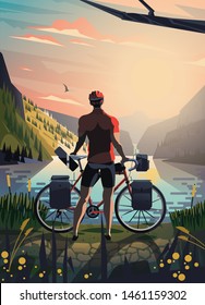 Guy with bicycle standing in front of the lake in the mountains