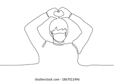 The guy folded his arms over his head making a heart shape with his fingers. Korean gesture "saranhe" which means "I love you". Declaration of love, falling in love, gratitude