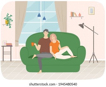 Guy and girl hug on couch in living room. People in relationship spend time together at home