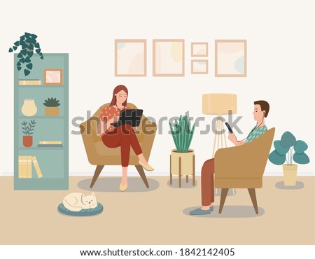 A guy and a girl are sitting in the same room and each on the Internet. A young woman and a man work at home.