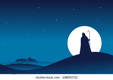 Guy in hooded cloak with a stick walking to a village in the night.