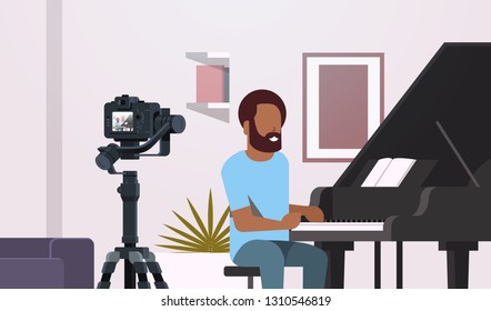 guy musical blogger recording video on camera african american man playing classical piano music blog concept. modern apartment interior closeup portrait horizontal