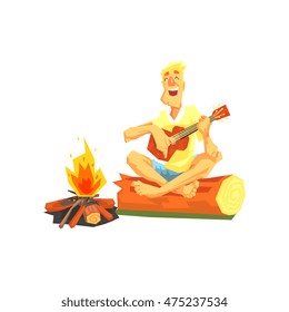 Guy Playing Guitar Sitting On A Log Next To Bonfire