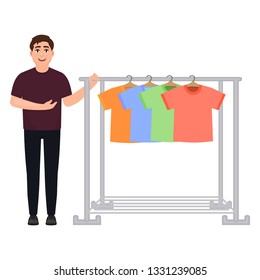 The guy shows off a wardrobe of t-shirts, a man sells t-shirts, a clothes hanger, a character in a cartoon style.