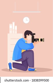 The guy sitting and adjusting the camera. Photographic art. A man prepares camera for a photo shoot. Photographer with camera takes picture in the library. Book storage, Room with bookcases