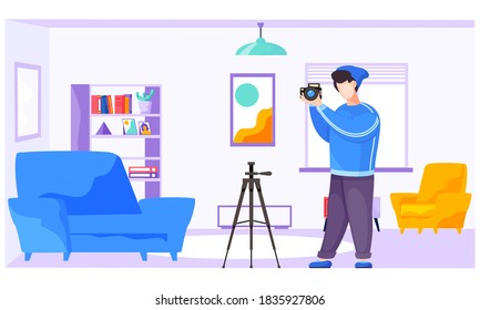 The guy standing and adjusting the lens. Photographer with a camera and a tripod in the apartment. Taking photos at home. Photographic art. A cameraman prepares camera for a future photo shoot