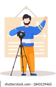 Guy standing with the camera and a tripod. Cameraman prepares camera for a photo shoot. Photographer takes picture in the photo studio with the plate with text on the background. Guy raises his hand