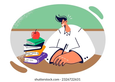 Guy student sits at school table with books and holds pen, recording lecture and getting quality education. Student attend classes at college or university wishing to gain new knowledge