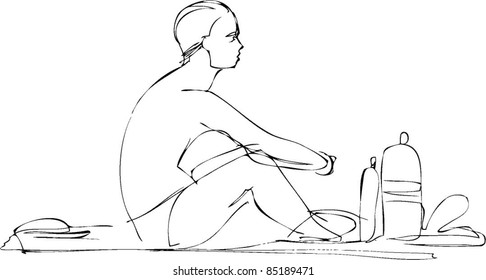 guy in swimming trunks sitting on the beach