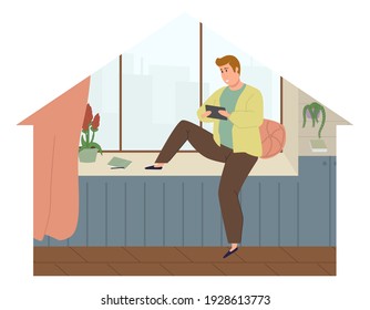 El tipo trabaja con una tableta o teléfono sentado en el umbral de la ventana y mirando por la ventana en casa. Ilustración vectorial del trabajo independiente al estilo de dibujos animados planos.

