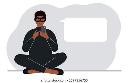 Hacker in a black mask with a mobile phone. The cybercriminal is holding a smartphone. Cyber attack, mobile phishing, scam.