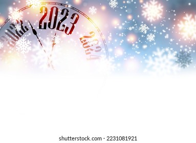 Half hidden clock showing 2023 on blue snowflakes and bokeh background. Space for text.