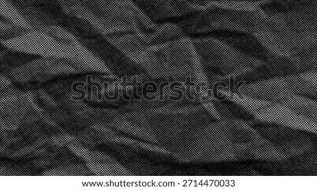 Halftone crumpled paper texture with wite a dotted, rough, and wrinkled surface. Black creased sheet background in comic pop-art style, featuring grainy folds and gritty distressed details.	