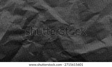 Halftone crumpled paper texture with wite a dotted, rough, and wrinkled surface. Black creased sheet background in comic pop-art style, featuring grainy folds and gritty distressed details.	