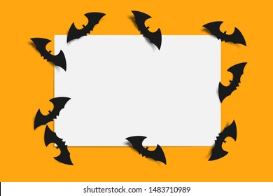 Halloween bat on white paper on orange background.