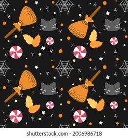 Halloween seamless pattern with broom sticks, spider webs, candies, black cats and orange toned leaves on black background
