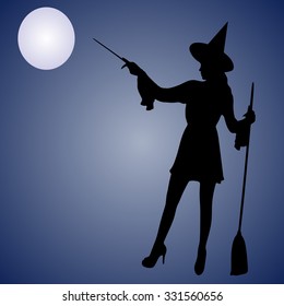 Halloween Witch. Beautiful young woman in witches hat and costume holding magical wand in her hand