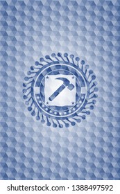 hammer icon inside blue emblem or badge with abstract geometric pattern background.