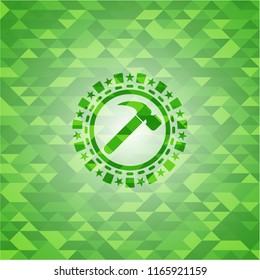 hammer icon inside green emblem. Mosaic background