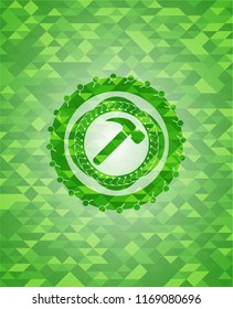 hammer icon inside green emblem with mosaic background