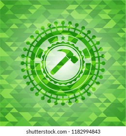 hammer icon inside green emblem with mosaic ecological style background