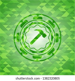 hammer icon inside green emblem with mosaic ecological style background