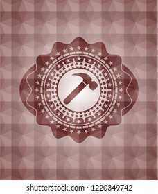 hammer icon inside red seamless emblem or badge with abstract geometric pattern background.