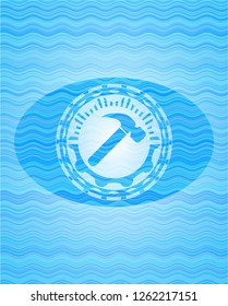 hammer icon inside sky blue water wave style emblem.