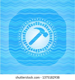 hammer icon inside sky blue water emblem.
