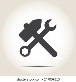 Hammer and wrench on a gray background