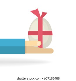 Hand with big egg with a red bow isolated on a white background.Chicken egg.