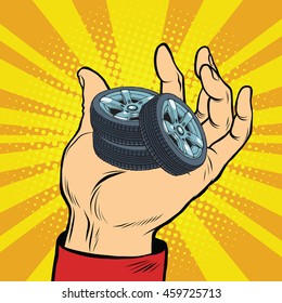 Hand with car tires pop art retro comic book vector illustration. sale of spare parts