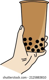 hand carrying a glass of thai tea with boba topping