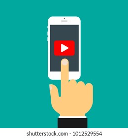 The hand clicks on the screen of the smartphone. Play button