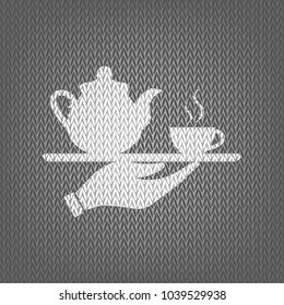 Hand with cup of coffee or tea sign illustration. Vector. White knitted icon on gray knitted background. Isolated.