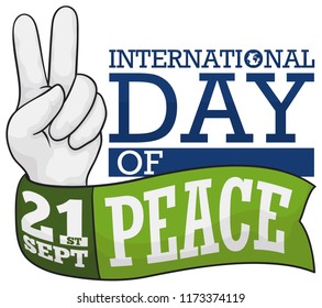 Hand doing the peace gesture and a green ribbon around it to celebrate International Peace Day this 21st September.