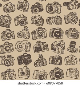 Hand drawing doodle sketching modern SLR photo cameras. Seamless brown pattern background.