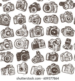 Hand drawing doodle sketching modern SLR photo cameras. Seamless pattern background.