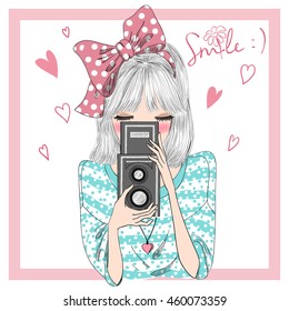 Hand drawn beautiful cute girl with bow on her hair and with camera in hands. Vector illustration.